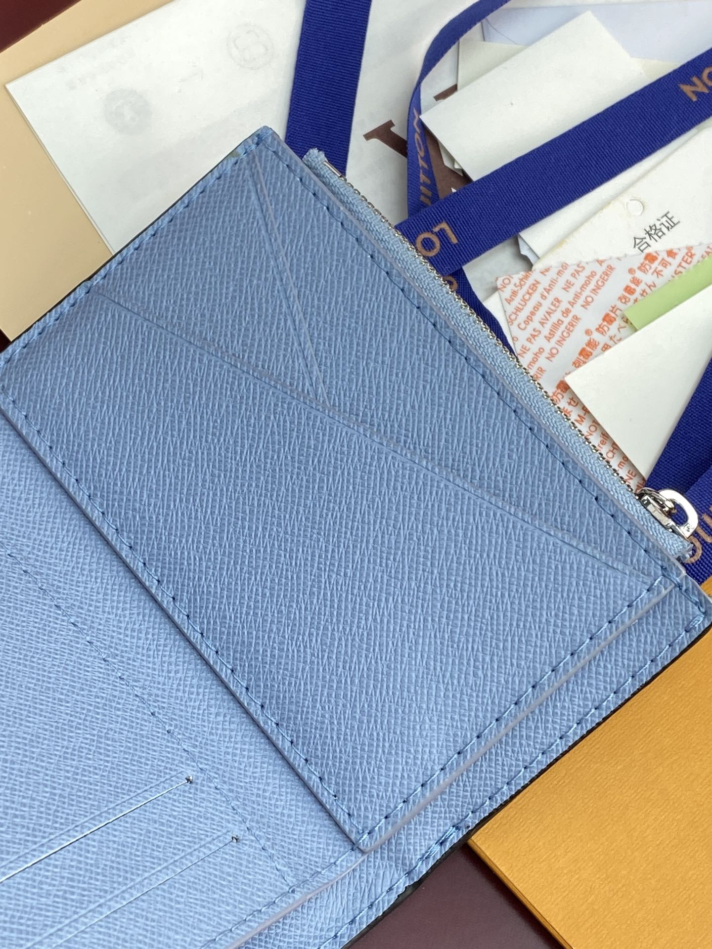 Light blue Louis Vuitton small bag with stitched edge and monogram flap corner detail