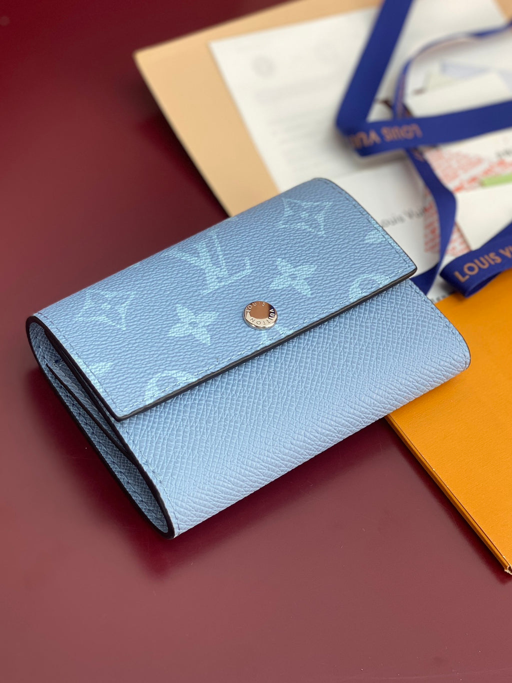 Light blue Louis Vuitton small bag with monogram flap and centered gold snap