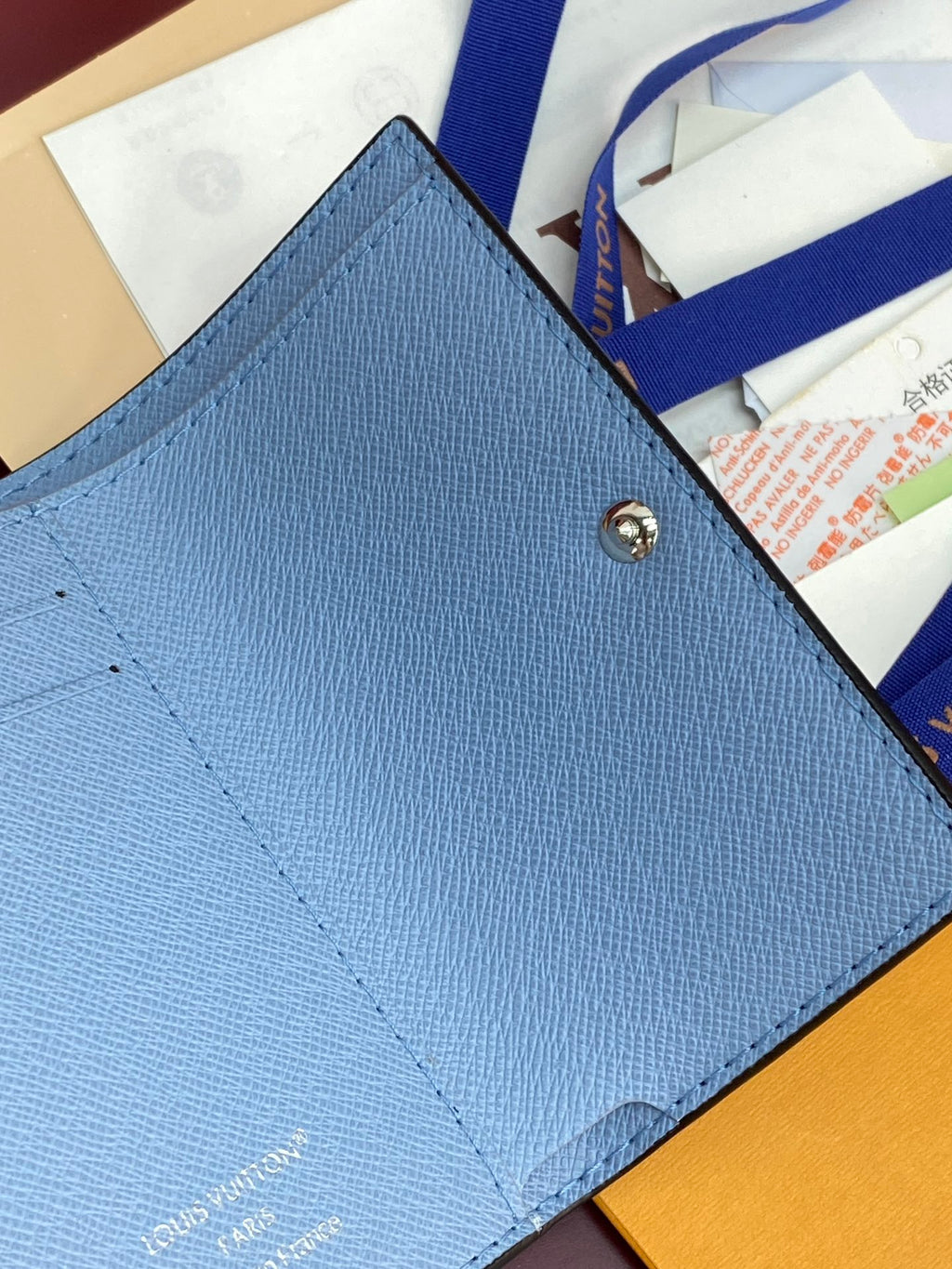 Light blue Louis Vuitton card holder-style small bag with monogram flap and gold button