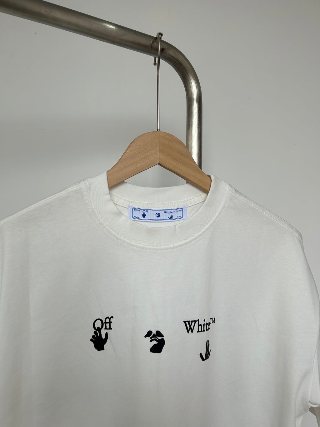 Off-white T-shirt with centered blue-and-black graphic and script lettering