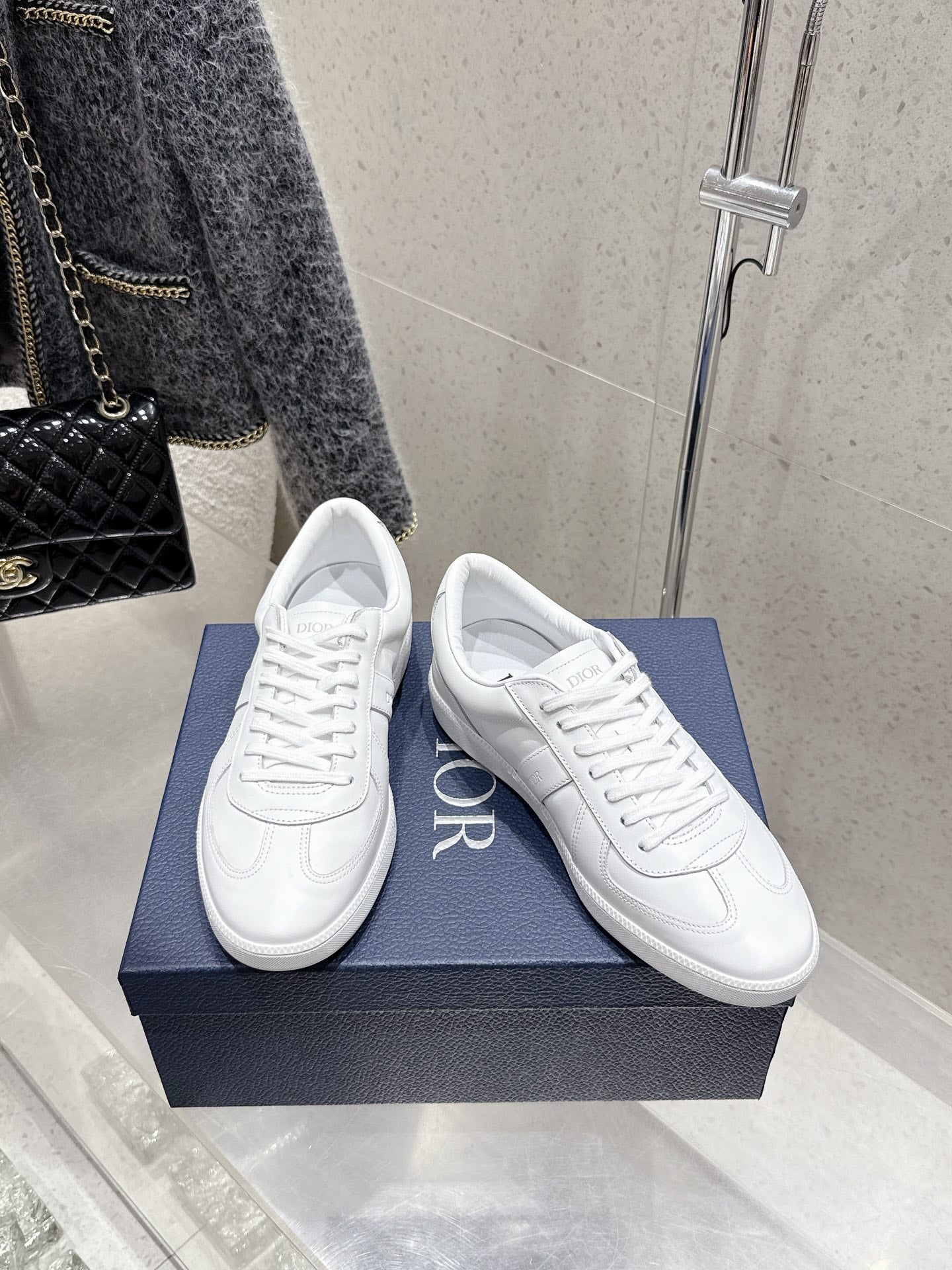 White Dior unisex sneakers, angled front view with Dior logo on sides