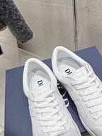 Pair of white Dior unisex sneakers, toe and tongue view with logo