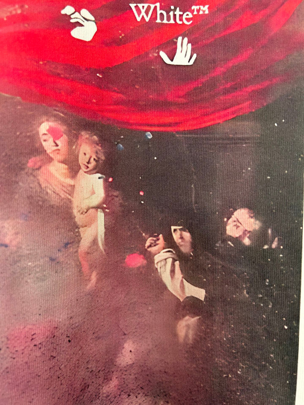 Off White T-shirt close-up showing red top banner and faces in graphic print