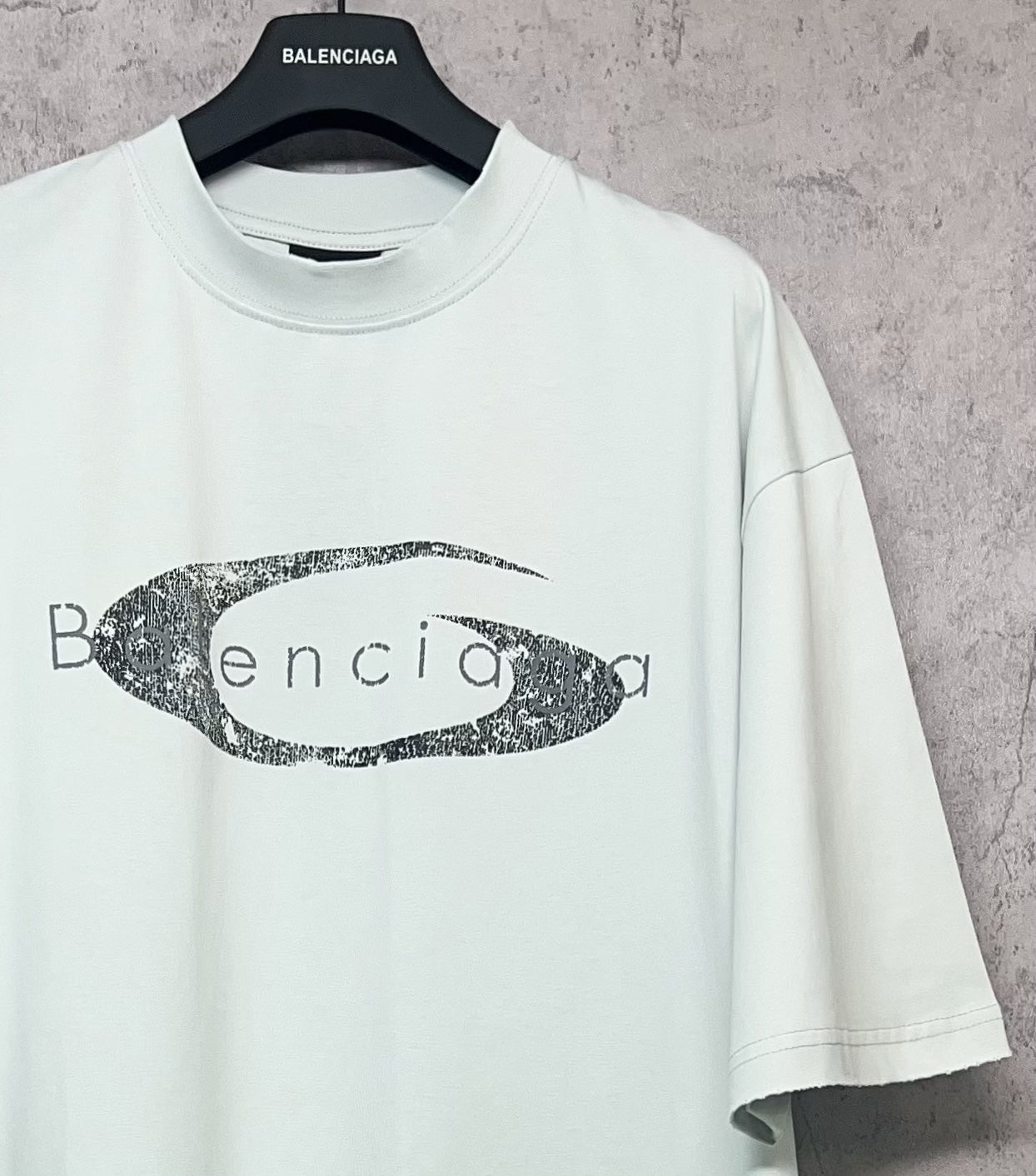 Balenciaga short-sleeve T-shirt in light mint with oval graphic logo print, angled view