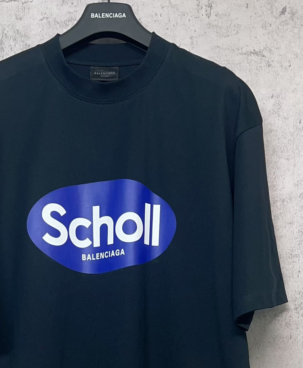Balenciaga short-sleeve T-shirt, dark navy, close-up of front “Scholl” oval logo