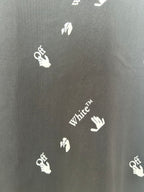 Black T-shirt fabric close-up with white hand and White text logos