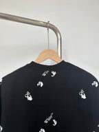 Black T-shirt back view with white hand logos across shoulders