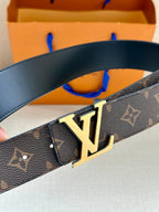 Louis Vuitton monogram belt with gold buckle, dark brown patterned leather close-up