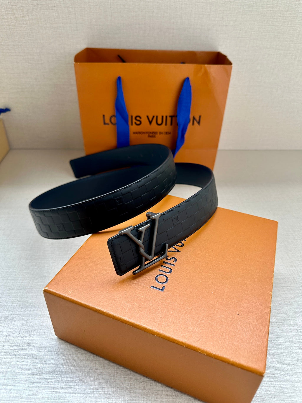 Dark navy belt with LV buckle and quilted embossed strap