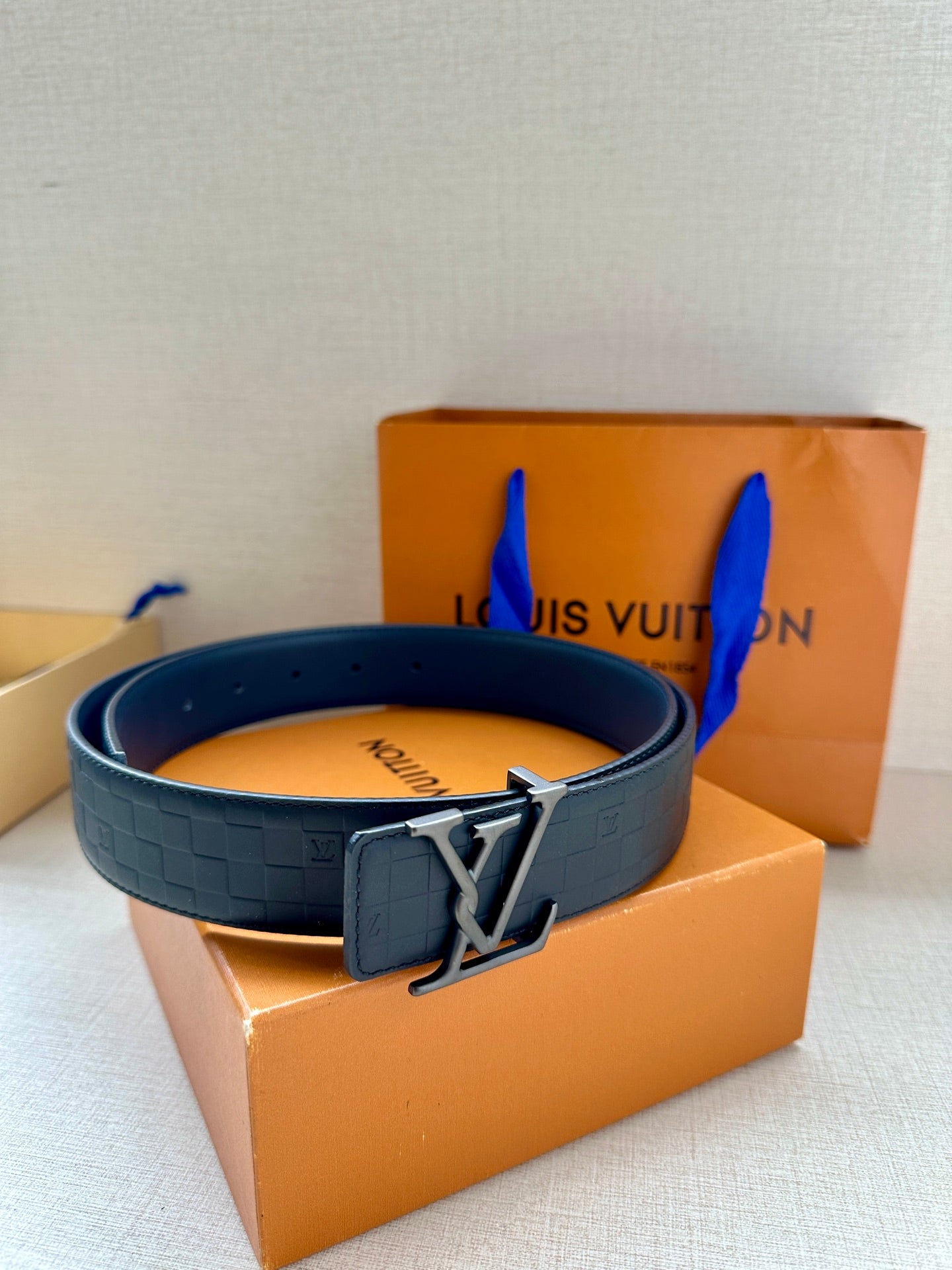 Dark navy belt with embossed pattern and LV silver-tone buckle