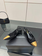 Black and gold ballet flats with bow laces, CHANEL logo visible on the shoe.