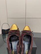 Pair of women’s flats with burgundy suede and gold toe panel, lace-up bows, rounded toe.