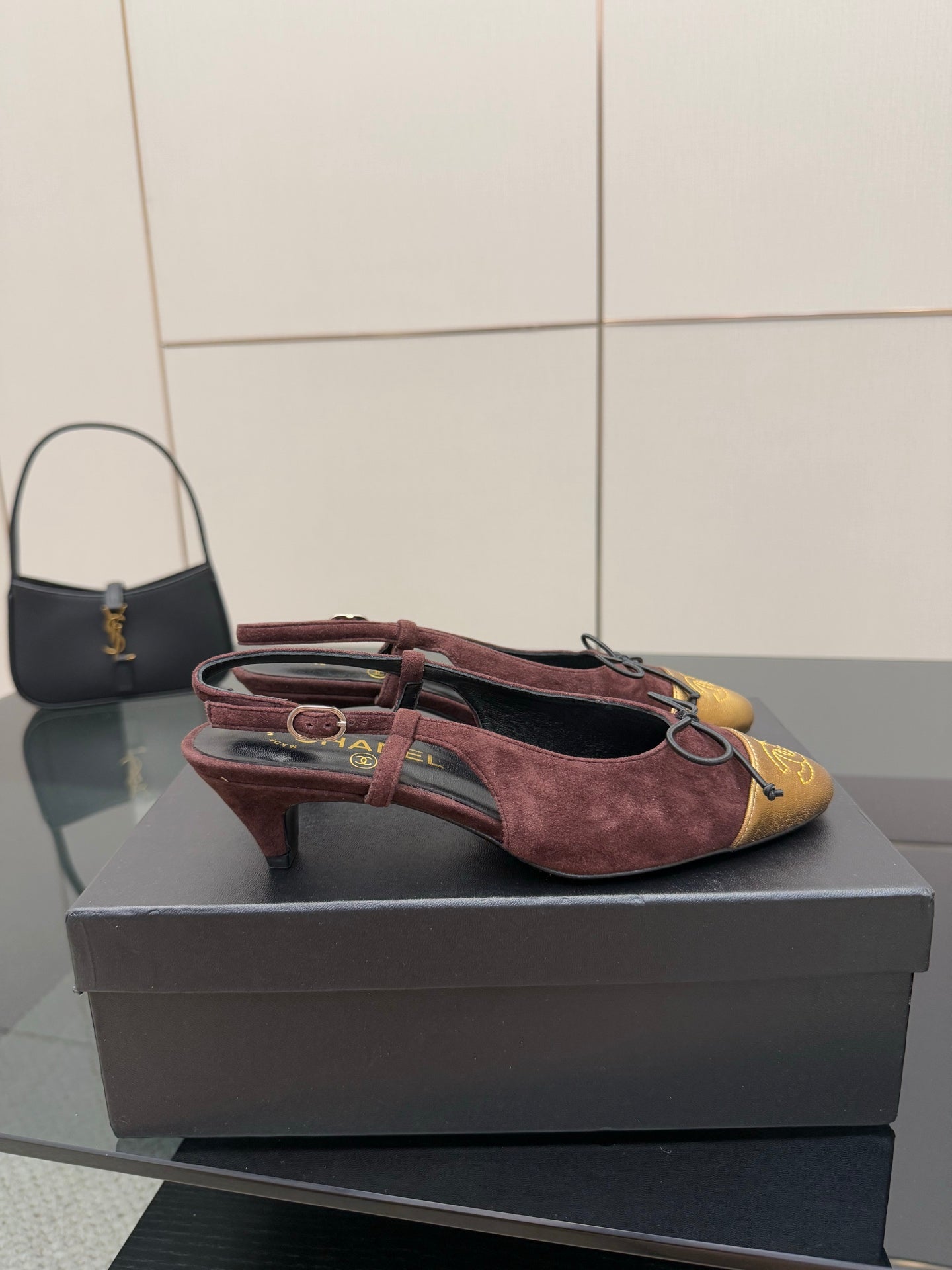 Women’s low-heel flats, burgundy suede with gold toe cap and red laces, side view.