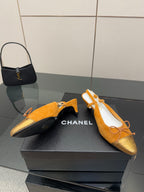 Tan suede flats with lace-up bows, gold toe embroidery and kitten heel