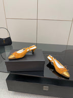 Tan and gold flats with lace-up bow front, displayed on black shoe boxes
