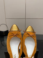 Tan suede ballet flats with lace-up bows, gold toe caps and kitten heels