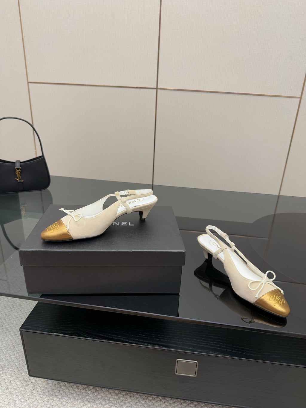 Women’s slingback heels with bow ties, white straps and gold toe caps on display