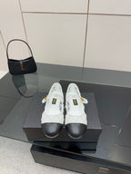 White lattice lace-up sneakers with black toe and gold Chanel emblem