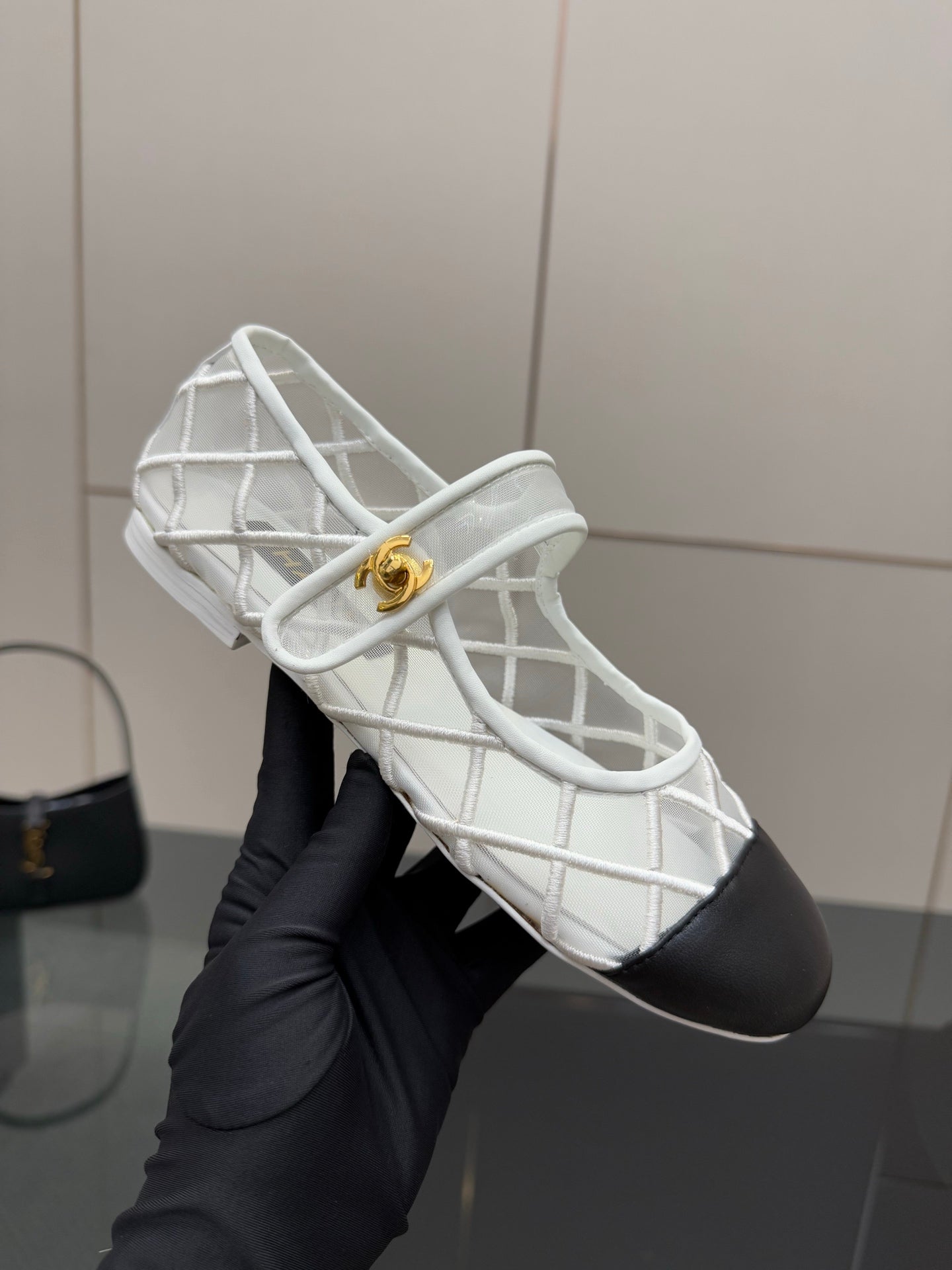 White lattice lace-up sneaker with black toe and gold Chanel medallion
