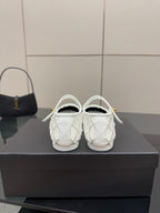 White lattice sneakers with black toe, gold emblem at top strap
