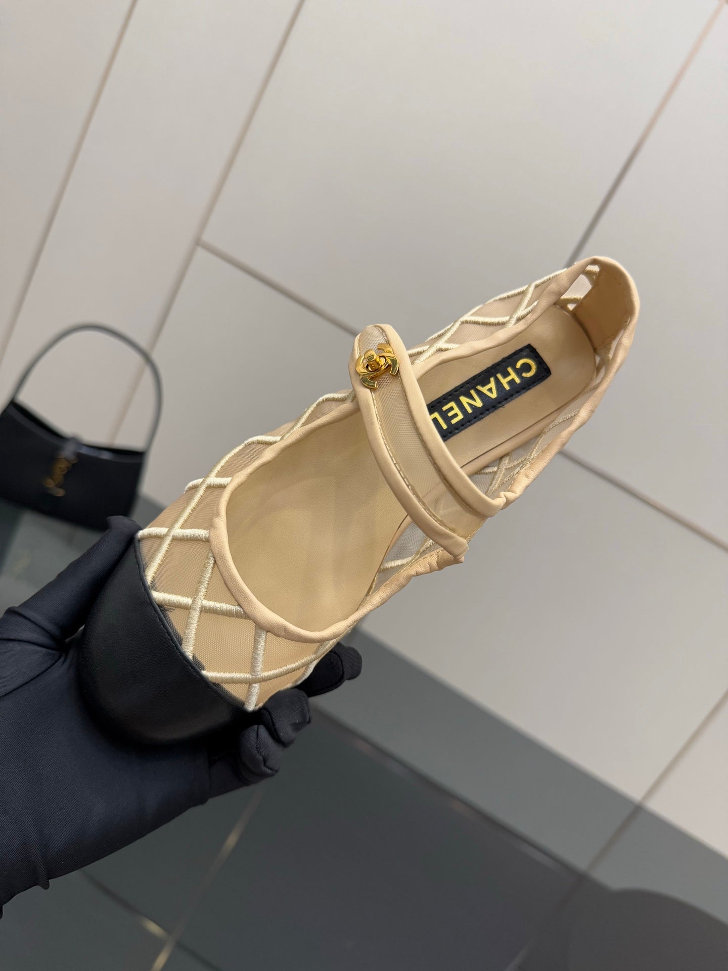 Chanel ladies beige flats close-up with gold logo on heel strap