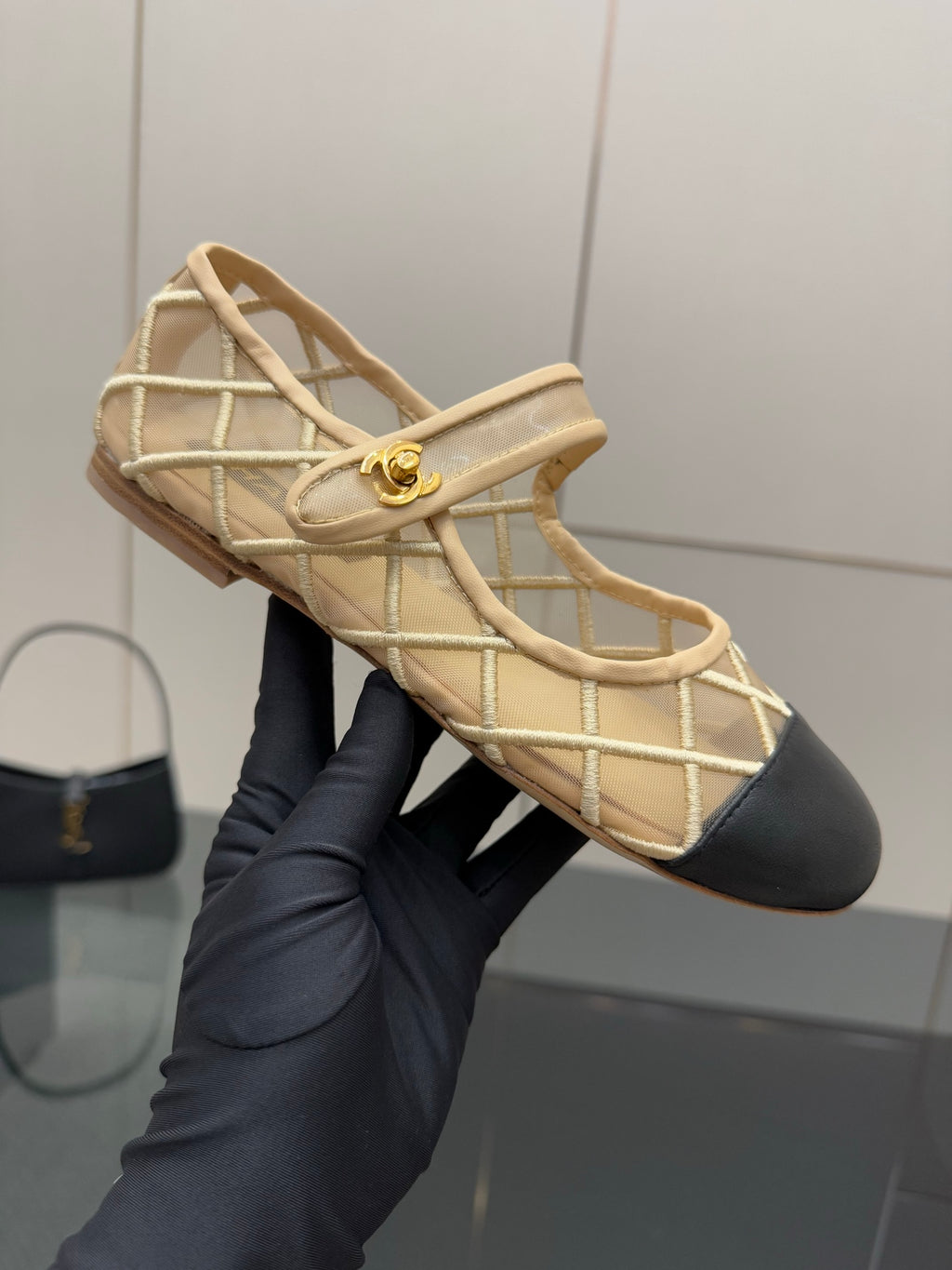 Chanel ladies beige flats close-up with gold emblem on lattice strap