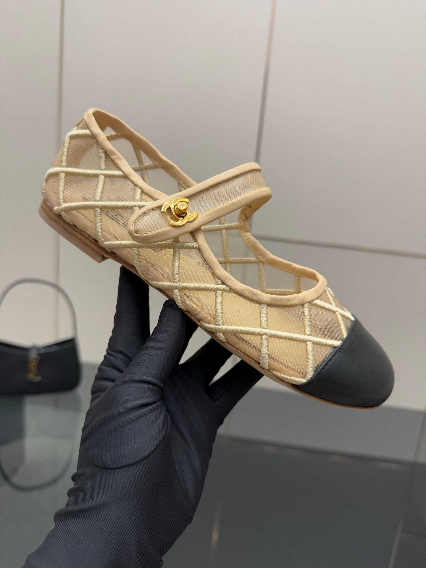Chanel ladies beige flats close-up with gold emblem on lattice strap