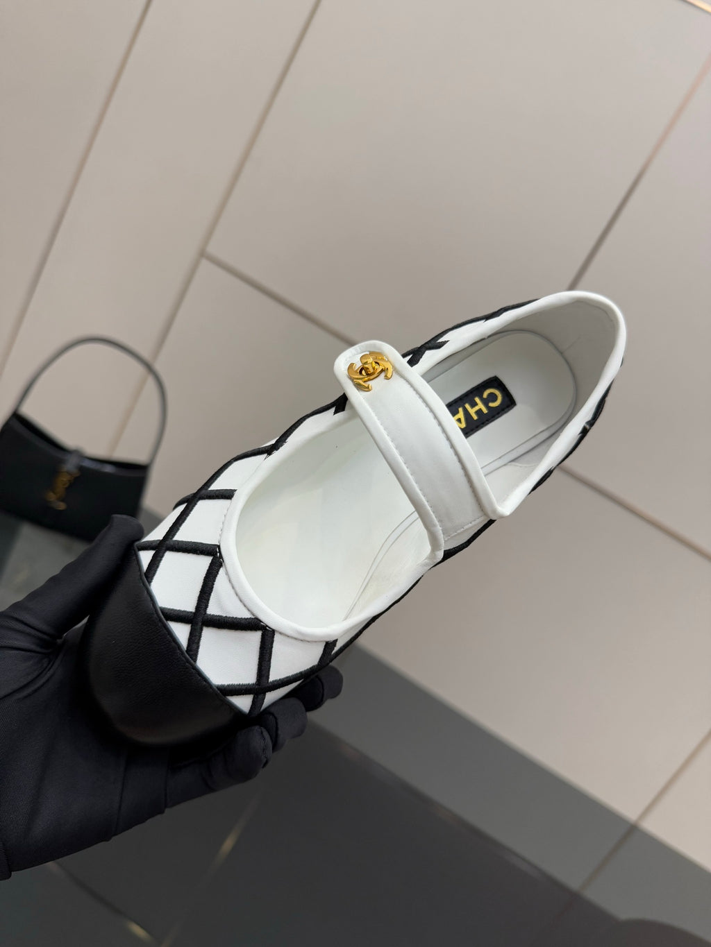 Side view of women's slip-on flats with CHANEL logo on strap, white and black