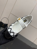 Side view of women's slip-on flats with CHANEL logo on strap, white and black