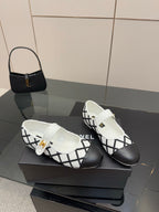 Pair of women's slip-on flats, white uppers with black crisscross pattern and gold detail