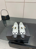 Women's slip-on flats with black lattice panels and white uppers, gold logo detail