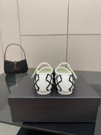Back view of women's slip-on flats, white and black lattice design with gold accents