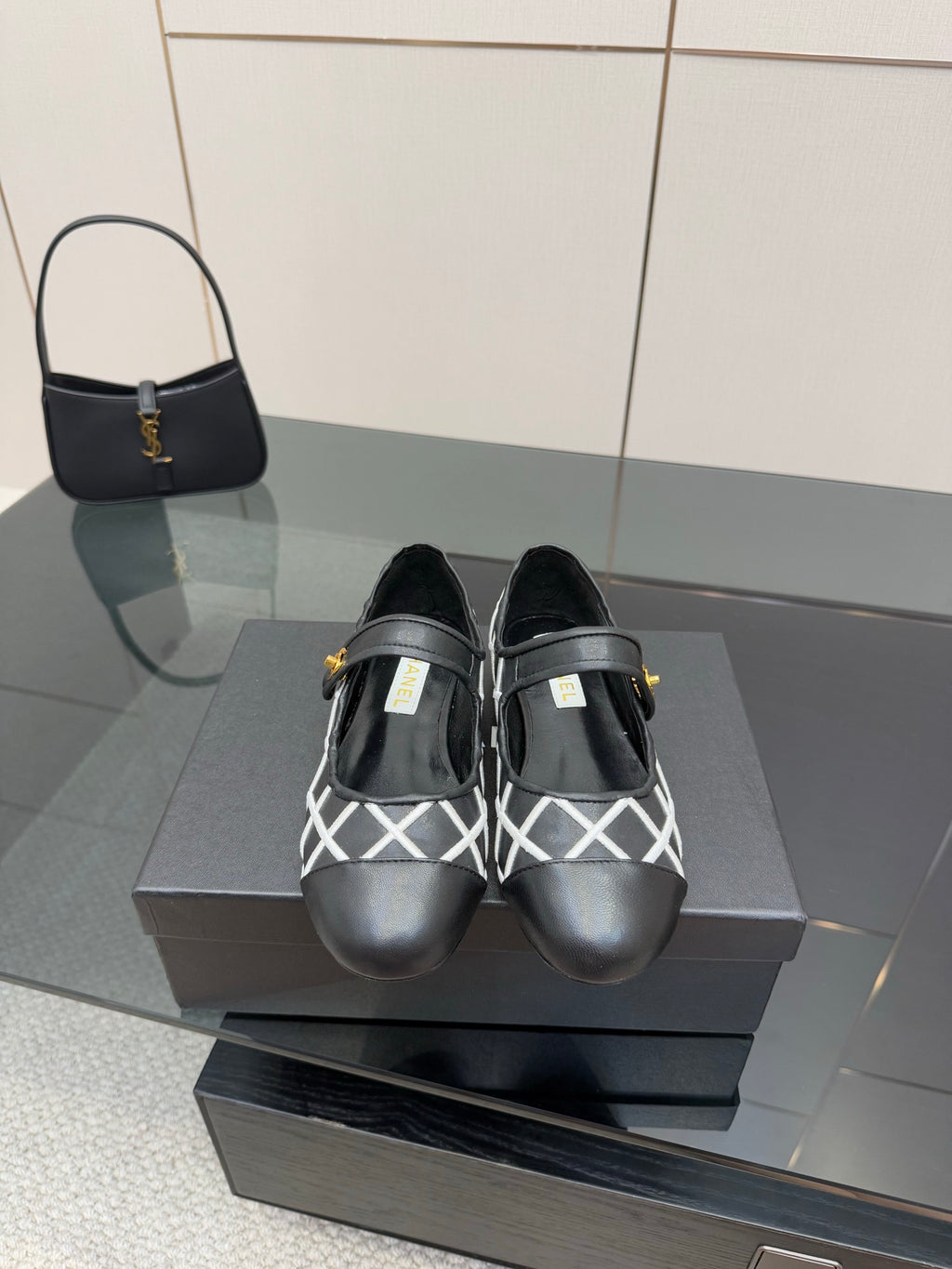 Black Chanel flats with white lattice straps and gold logo detail