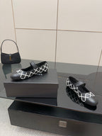 Black Chanel slip-on flats with white lattice upper and black strap