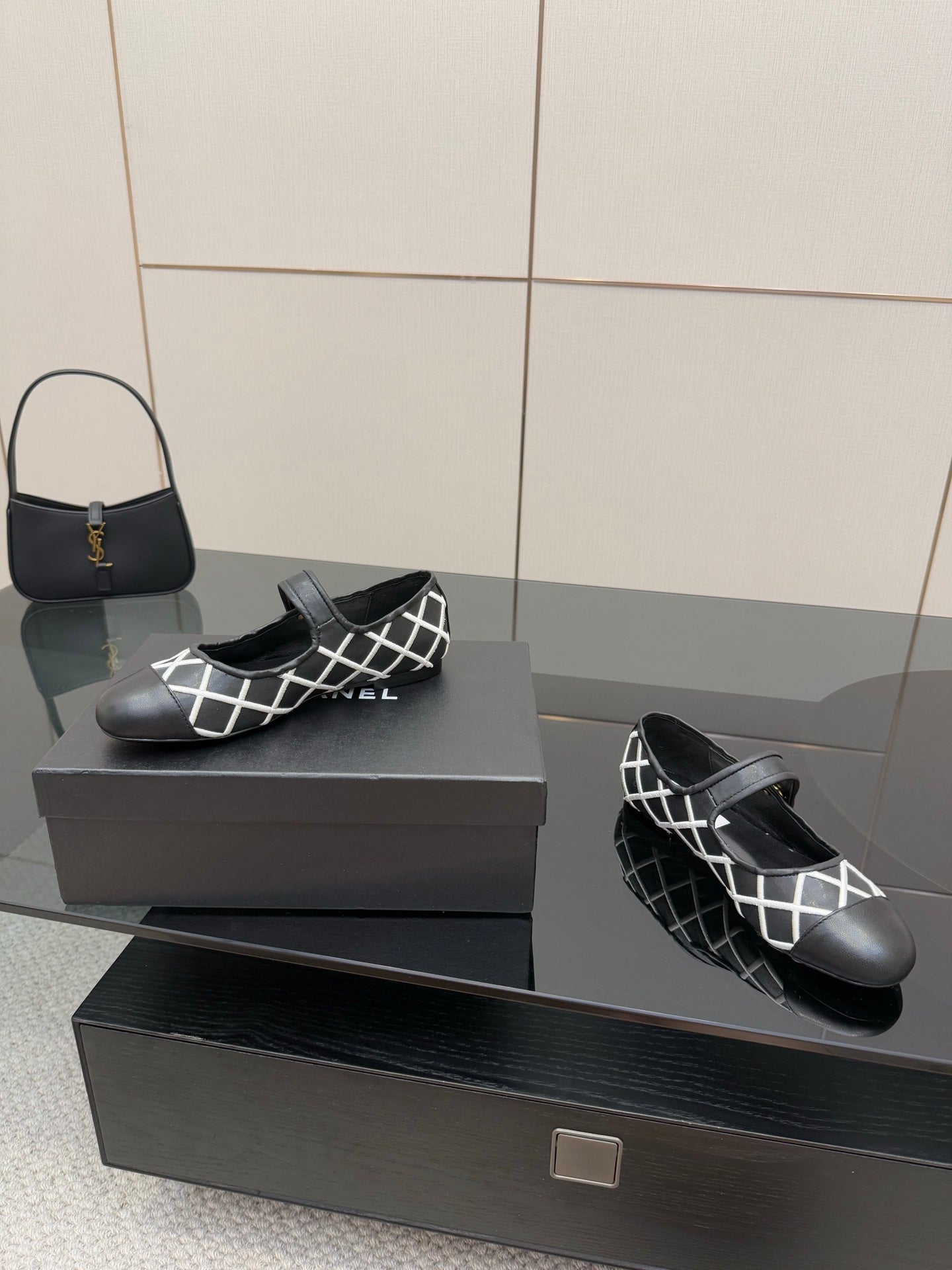 Black Chanel slip-on flats with white lattice upper and black strap