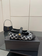 Black Chanel flats with white grid strap and gold logo center detail
