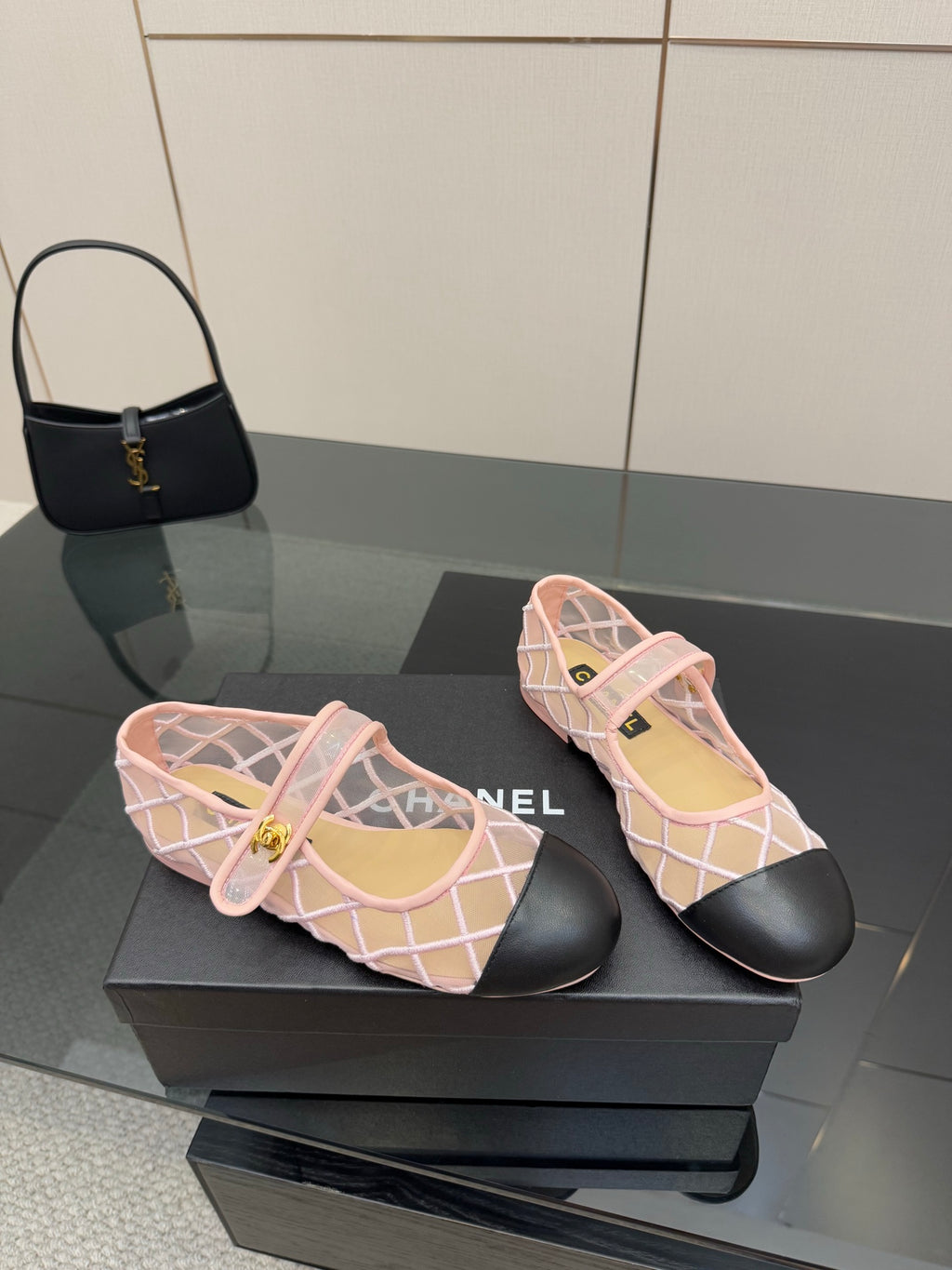 Pink mesh flats with white crisscross straps, black soles, gold logo charm