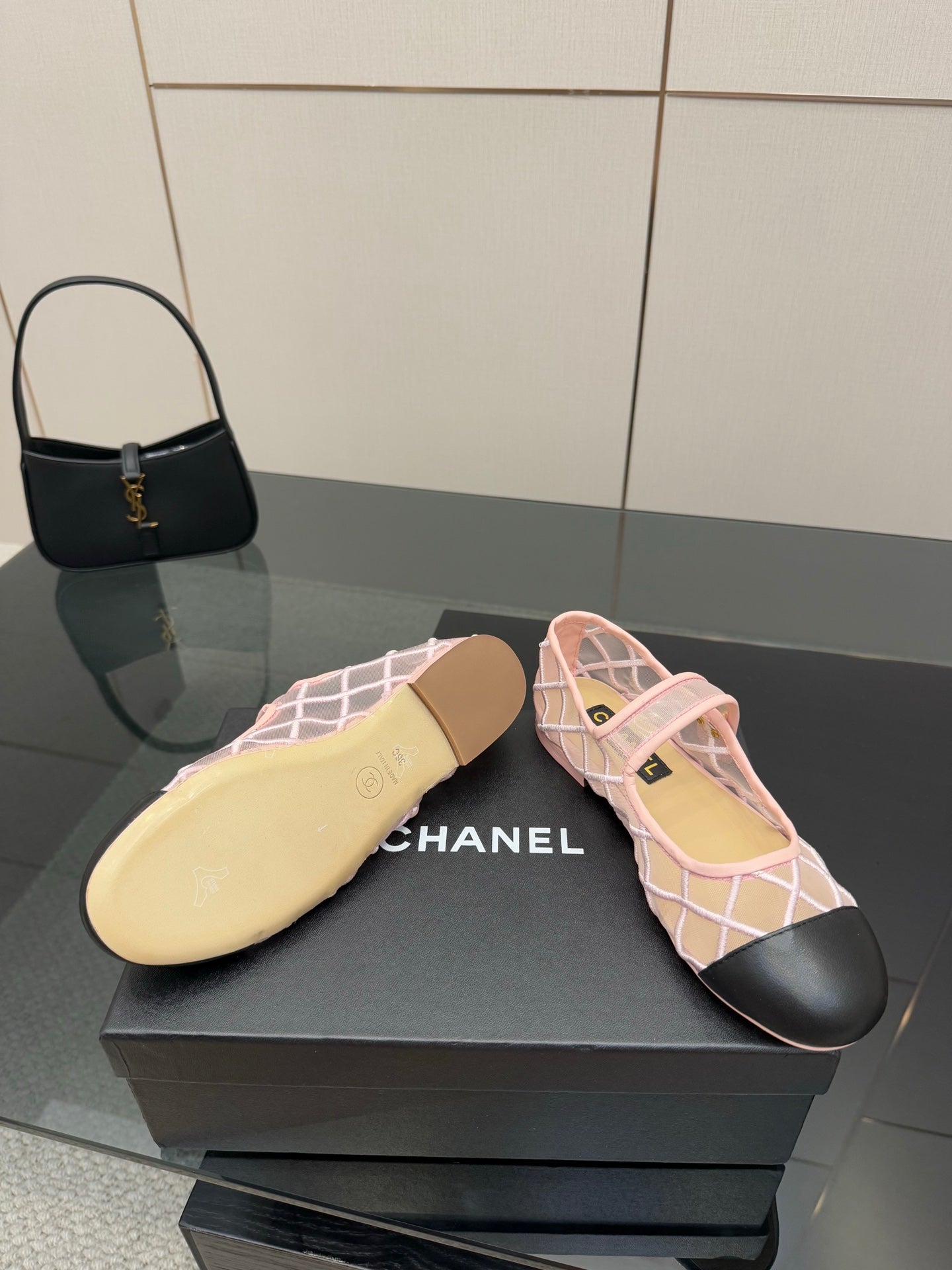 Pink lattice flats with black toe and beige sole underside