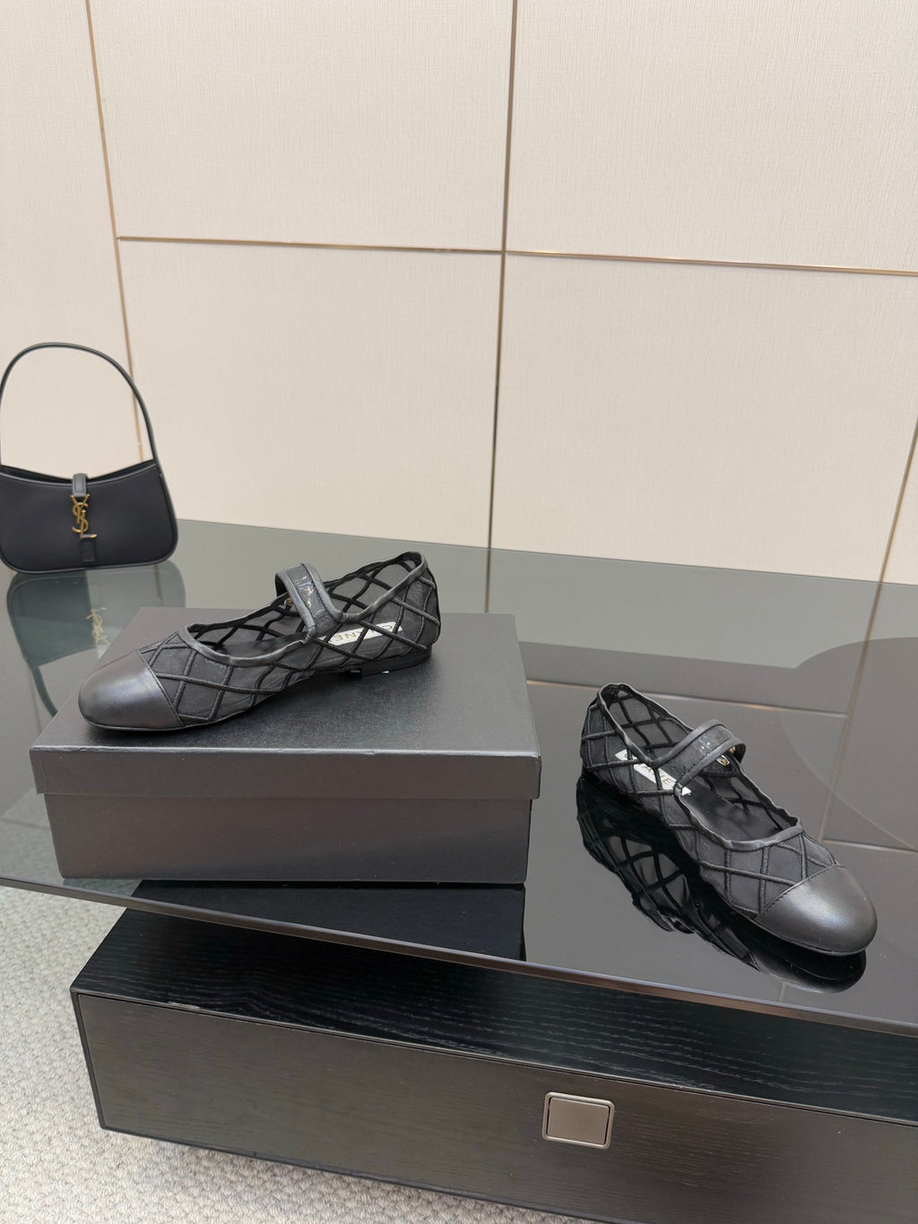 Chanel women’s black quilted flats with crisscross straps, angled pair on box