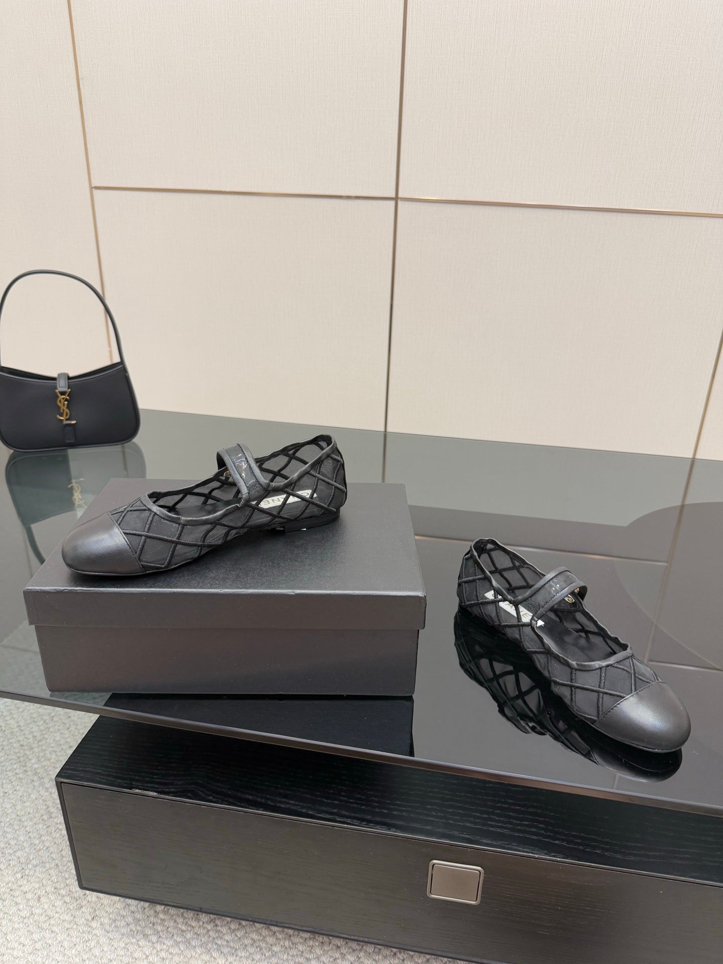 Chanel women’s black quilted flats with crisscross straps, angled pair on box