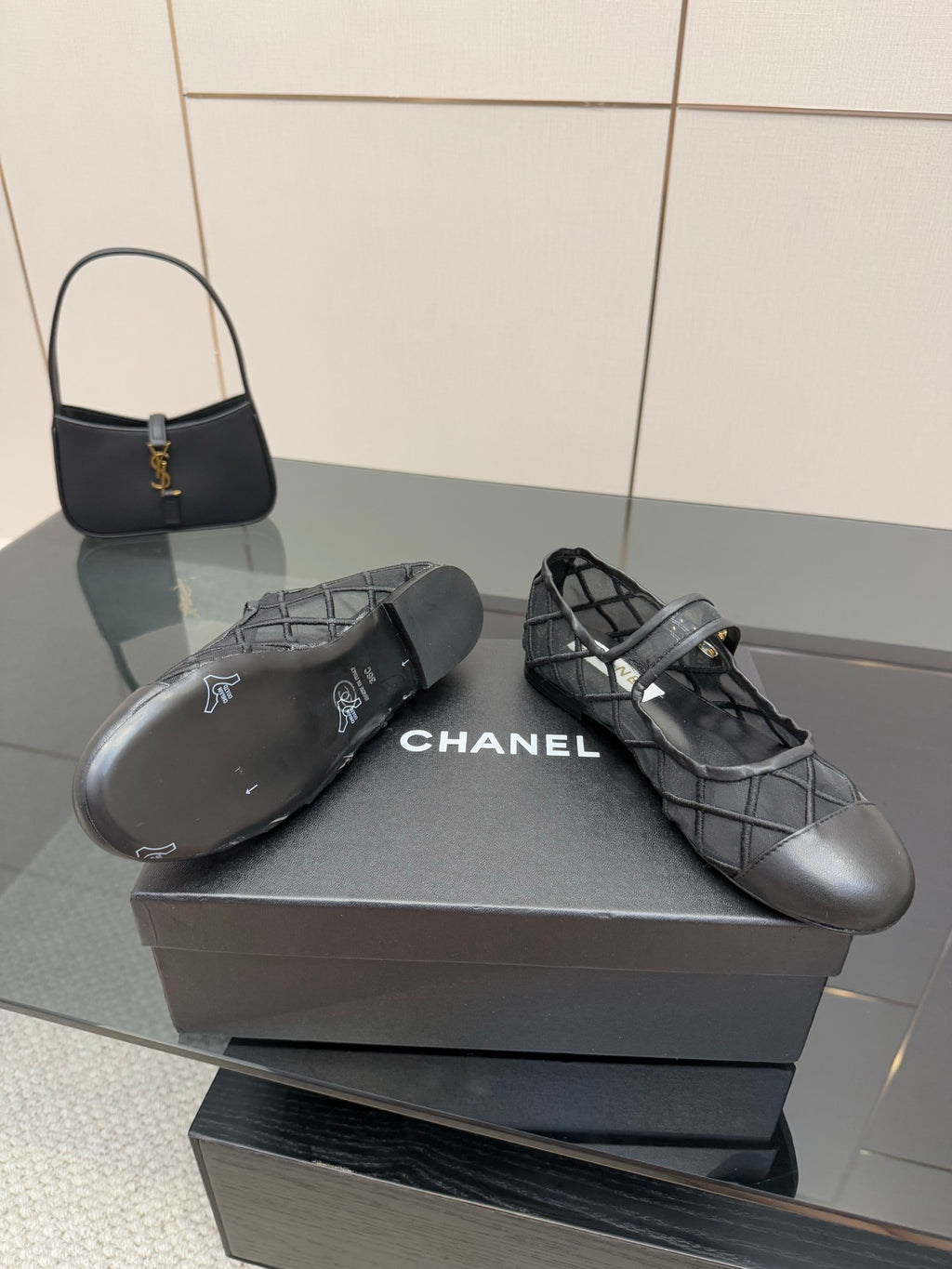 Chanel women’s black quilted flats with crisscross straps, close-up on box