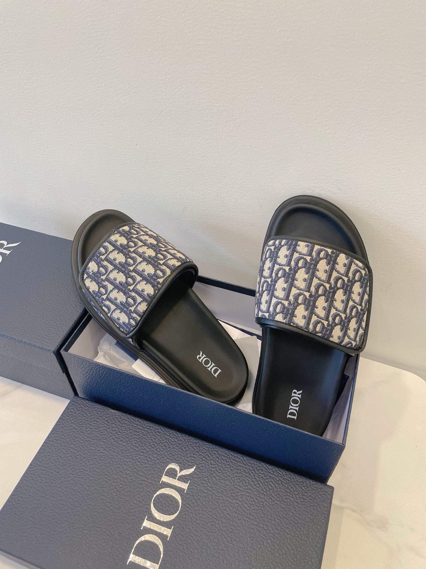 Dior slide sandals with navy monogram straps and black footbeds