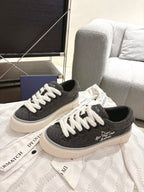 Unisex canvas sneakers with dark uppers, white laces, and white rubber sole