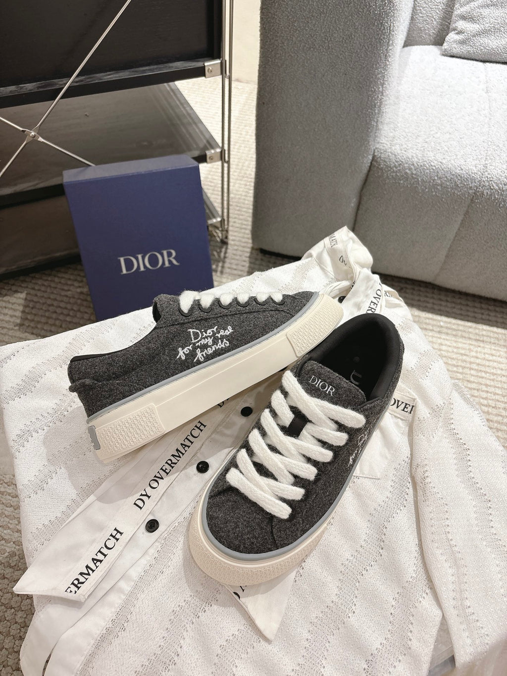 Unisex low-top sneakers on box, dark gray uppers with white laces