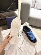Navy lace-up sneakers with light blue laces and textured white sole, DIOR logo on side