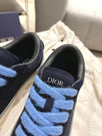 Close-up of navy sneaker upper with light blue laces and DIOR logo on tongue