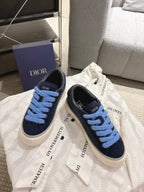Pair of navy low-top sneakers with light blue lace-up front and white sole, DIOR branding
