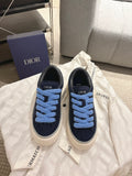 Navy low-top sneakers with light blue laces and white rubber sole, DIOR detail on side