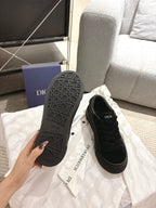 Black Dior sneakers soles up, molded tread pattern and low-profile cushioning