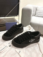 Pair of black lace-up Dior sneakers on display, front quarter view and cushioned tongue